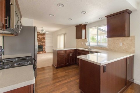 A kitchen with brown cabinets and a stove top oven.