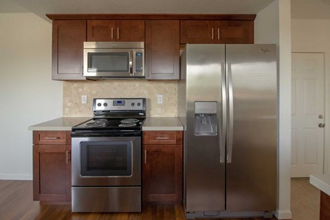 A kitchen with a stainless steel refrigerator and oven.