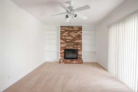 A room with a fireplace and a ceiling fan.