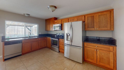 A kitchen with wooden cabinets and a black countertop.