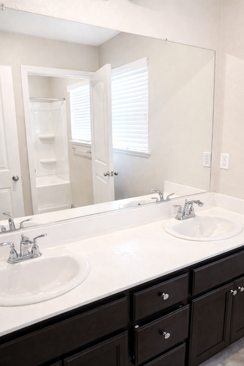 A bathroom with two sinks and a large mirror.