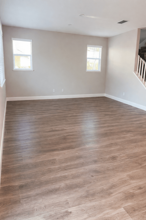 A room with wooden flooring and a staircase.