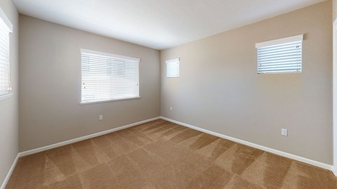 A room with tan carpet and white walls.