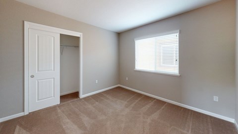 A room with a door and a window with blinds.