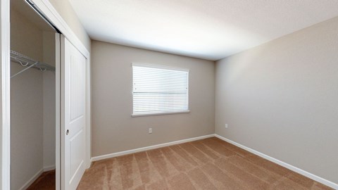 A room with a window and a closet.