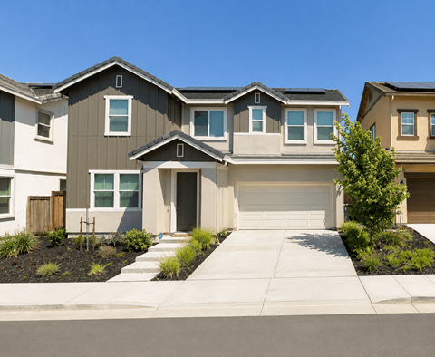 A row of houses with a clear blue sky above them.