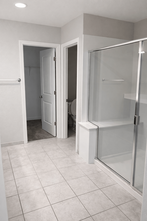 A white bathroom with a walk in shower.