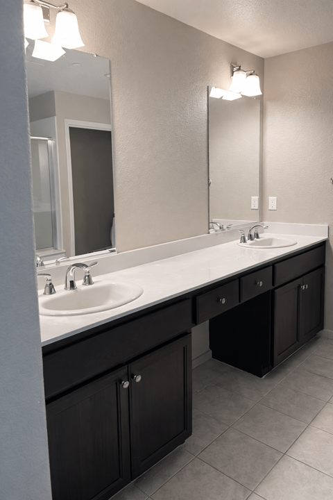 A bathroom with two sinks and a large mirror.