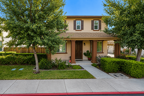 A house with a brown door and a red stripe on the sidewalk.