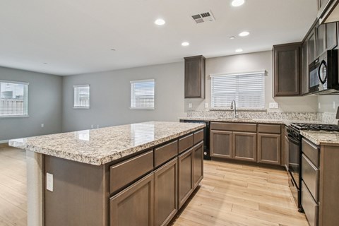 A kitchen with brown cabinets and a granite countertop.