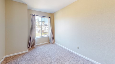 A room with a window and curtains.