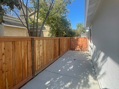 A wooden fence runs along the side of a house.
