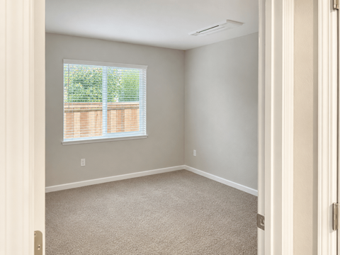 A room with a window and carpeted floor.