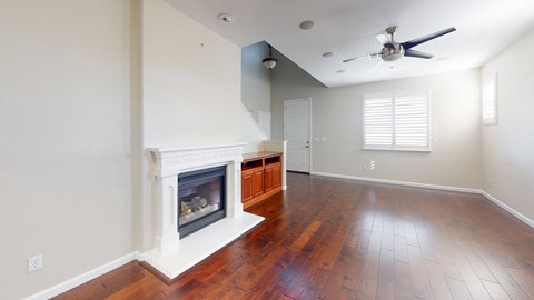 A room with a fireplace and wood flooring.