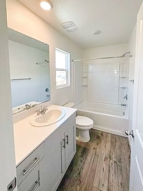 A white bathroom with a toilet, sink, and bathtub.