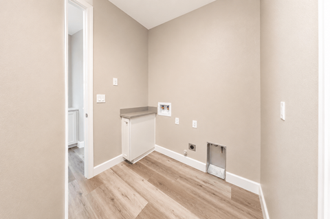 A room with a white fridge and a small white cabinet.