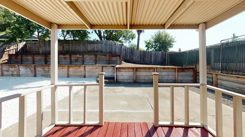 A wooden deck with a red floor and a white railing.