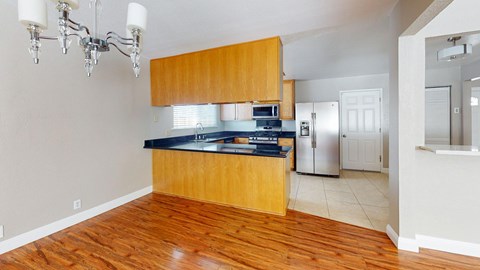 A kitchen with wooden cabinets and a black countertop.