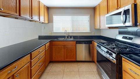 A kitchen with wooden cabinets and a black countertop.