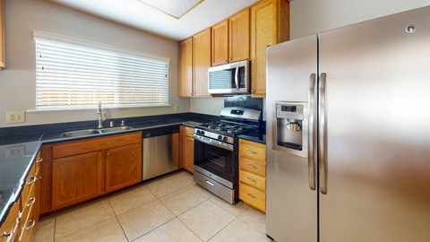 A kitchen with a stainless steel refrigerator, oven, and microwave.