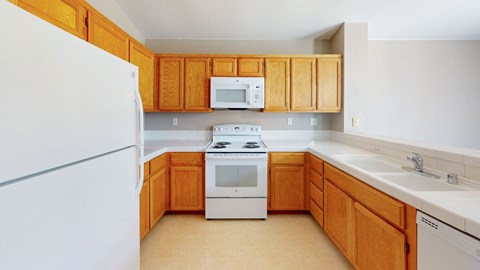 A kitchen with wooden cabinets and white appliances.