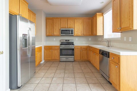 A kitchen with wooden cabinets and a refrigerator.