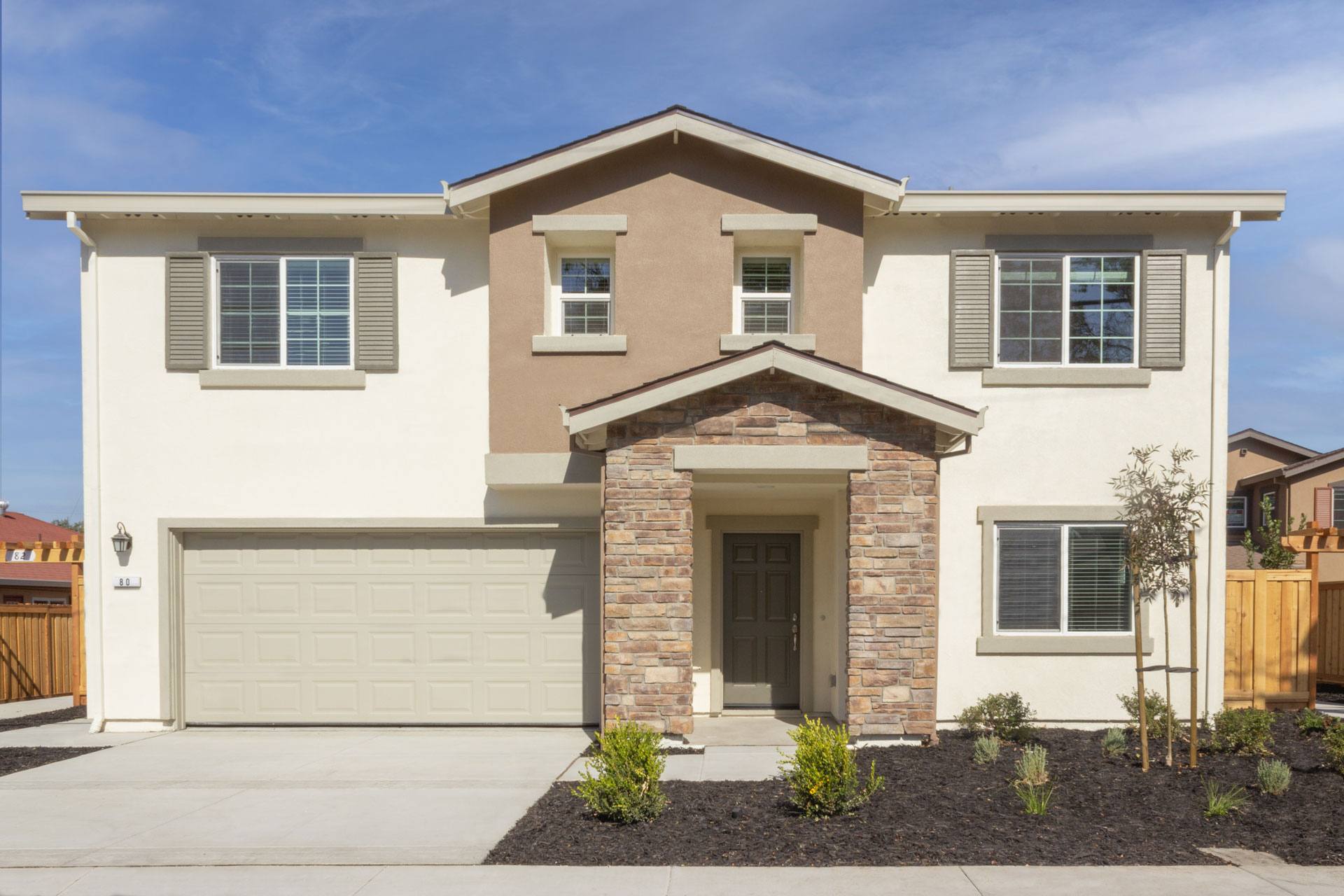 A modern two-story house with a garage and a front yard.