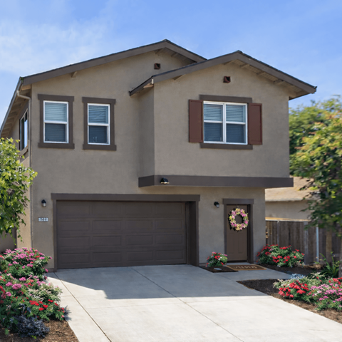 A house with a brown garage door and a wreath on the door.