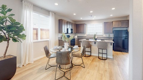 A modern kitchen with a dining table set for four.