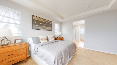 A bedroom with a bed, nightstand, and a painting on the wall.