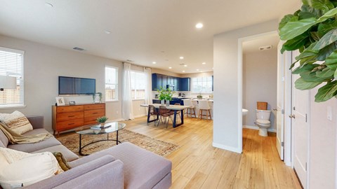 A living room with a grey couch and a wooden coffee table.