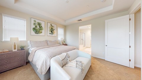 A bedroom with two beds and a white couch.