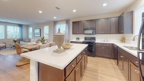 A modern kitchen with dark brown cabinets and a white countertop.