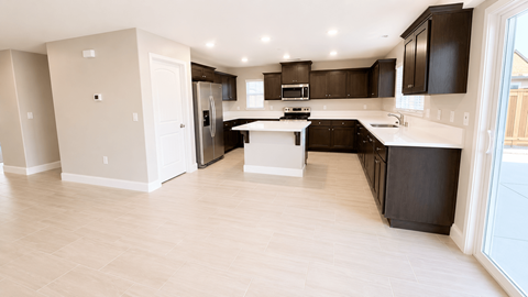 A kitchen with black cabinets and a white island.