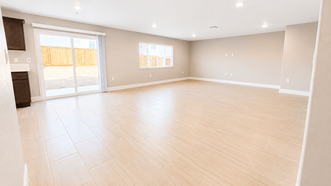 A spacious room with wooden flooring and a large window.
