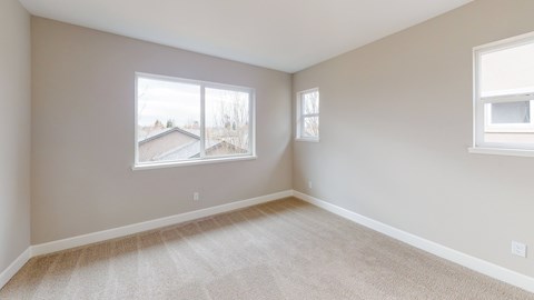 A room with a large window and a carpeted floor.