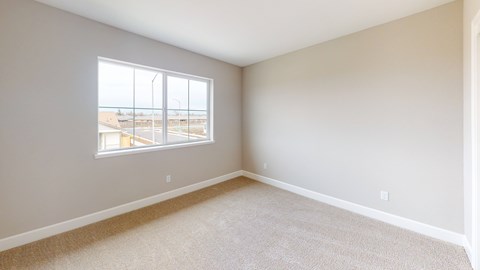 A room with a large window overlooking a parking lot.