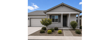 A house with a grey front yard and a small tree.