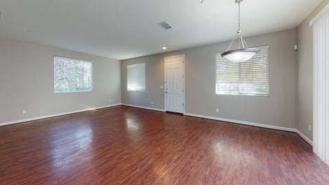 A room with wooden floors and a hanging light fixture.