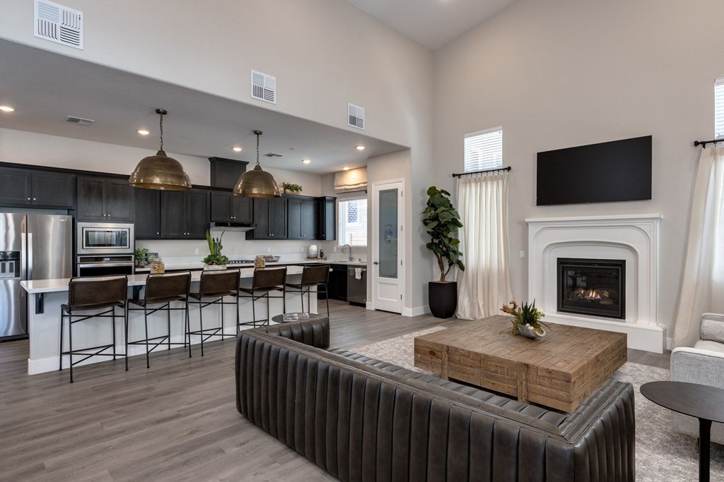 a living room with a fireplace and a kitchen with a table and chairs at Heritage Landing Apartments, Chico, 95973