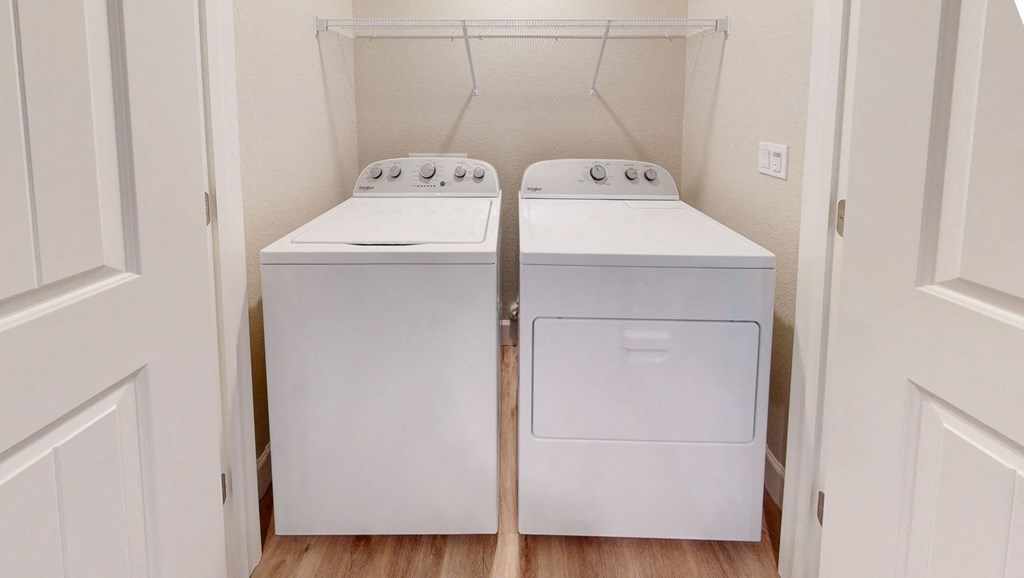two washers and dryers in a laundry room with a door at Heritage Landing Apartments, Chico, California
