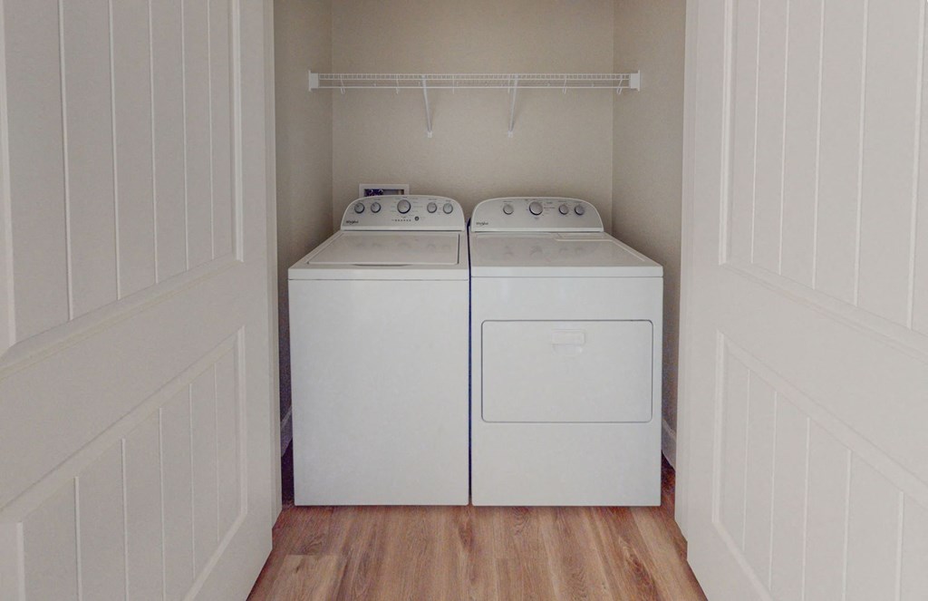 a washer and dryer in a laundry room with white walls and wood floors at Heritage Landing Apartments, Chico, CA, 95973