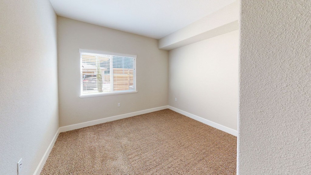 an empty room with carpet and a window at Heritage Landing Apartments, Chico, CA