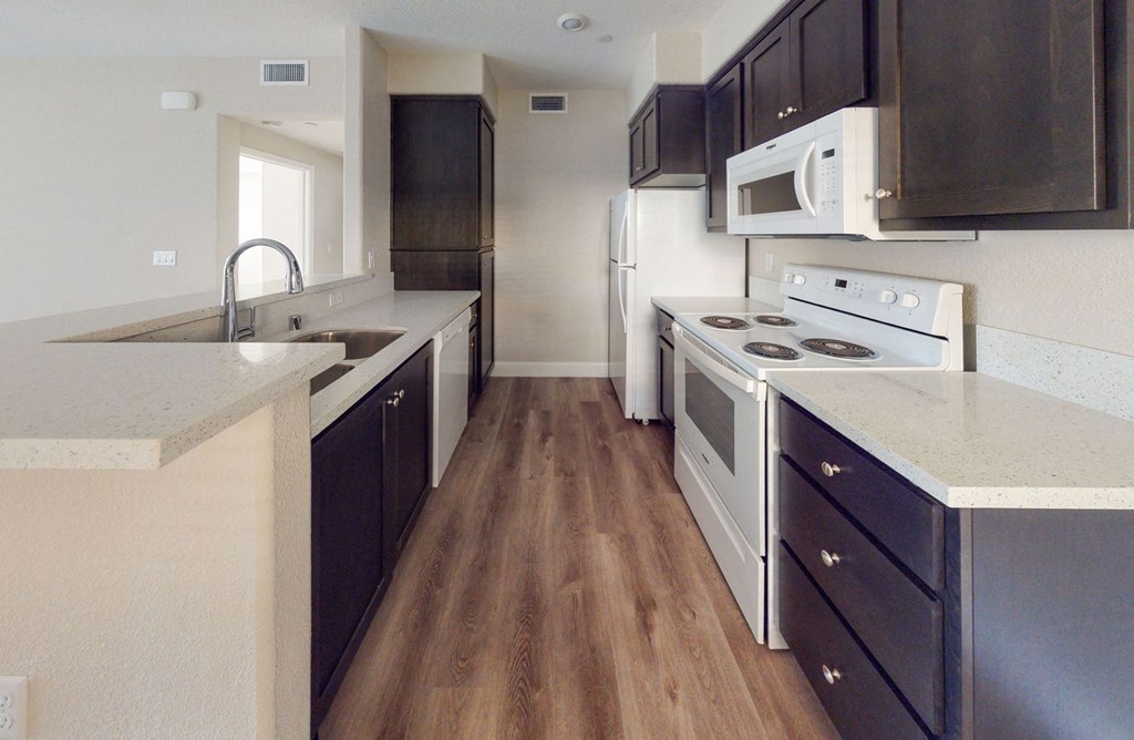 a kitchen with white appliances and black cabinets at Heritage Landing Apartments, Chico, CA, 95973