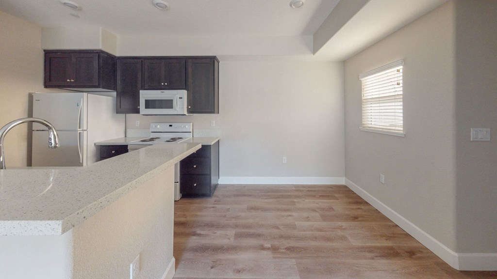 an empty kitchen with dark cabinets and a counter top at Heritage Landing Apartments, Chico, 95973