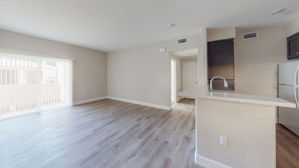 an empty kitchen and living room with hardwood flooring at Heritage Landing Apartments, Chico, California