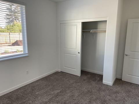 A room with a white door and a window with blinds.