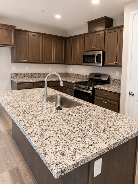 A kitchen with granite countertops and wooden cabinets.