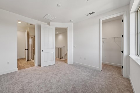 A spacious room with white walls and a carpeted floor.