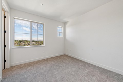 A room with a large window and a smaller window on the wall.
